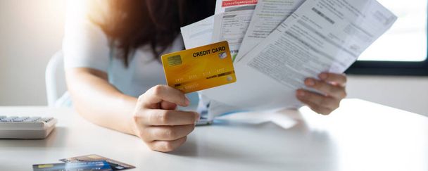 Ręka kobiety posiadającej kartę kredytową i narosły rachunek, dług i koncepcja upadłości - Zdjęcie, obraz