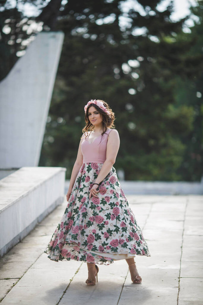 A shallow focus vertical shot of a woman on an outdoor pathway in a pink dress - 写真・画像