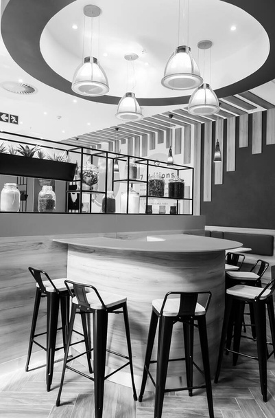 JOHANNESBURG, SOUTH AFRICA - Jan 06, 2021: A vertical grayscale shot of Popeyes fast food restaurant interior in Johannesburg, South Africa - Photo, Image