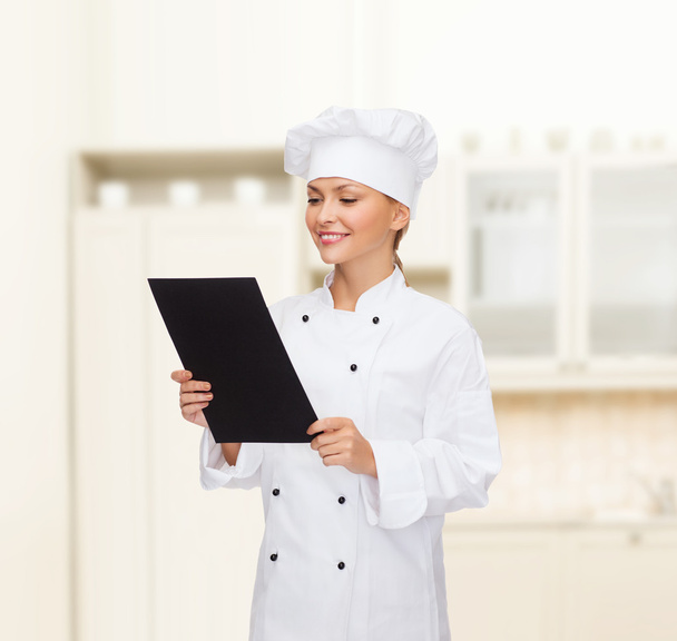 smiling female chef with black blank paper - Foto, Imagen