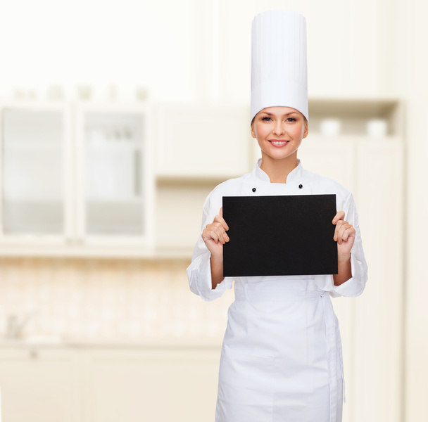 smiling female chef with black blank paper - Zdjęcie, obraz