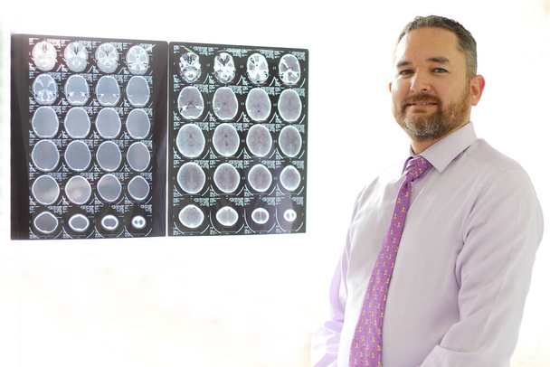 Lekarz Specjalista ds. Neurologii Zawodowej jego pracy przeglądy rentgenowskie mózgu lub tomografii komputerowej pacjenta - Zdjęcie, obraz