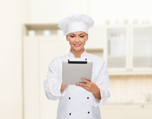 smiling female chef with tablet pc computer - Foto, imagen