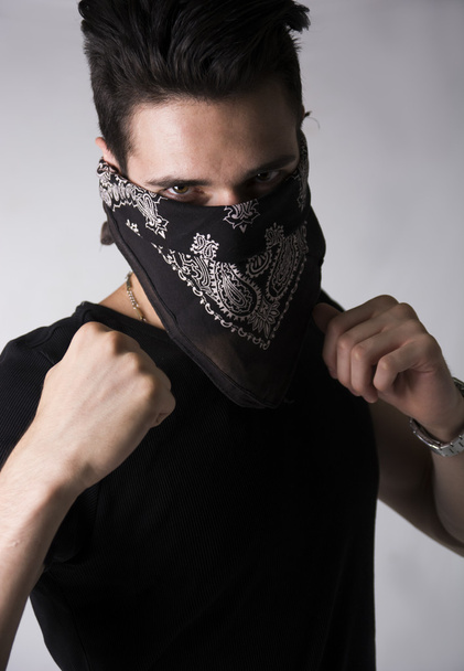 Man in a bandanna balling his fists aggressively - 写真・画像