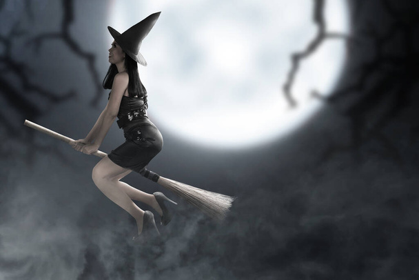 Asian witch woman with hat flying on a magic broomstick with a full moon background - Photo, image