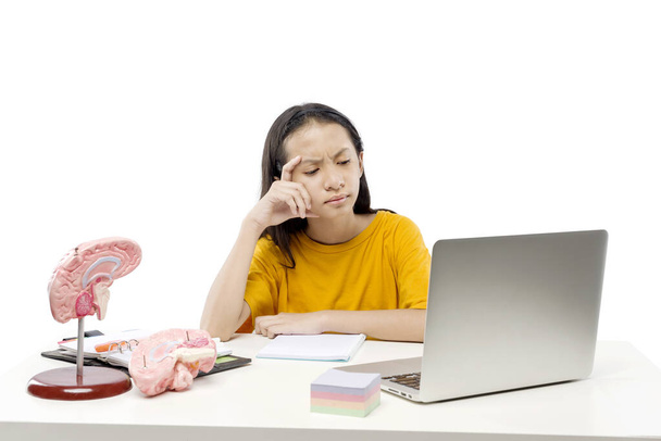 Asian little girl with laptop attending to online school class isolated over white background. Online education during quarantine - Foto, imagen