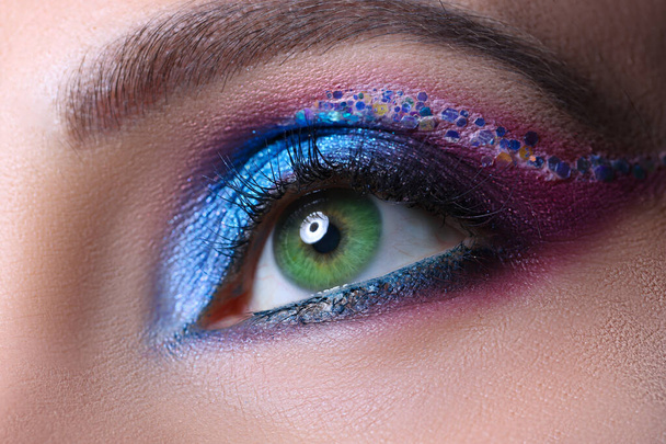Look of green female eyes with beautiful blue shades and black eyeliner closeup - Valokuva, kuva