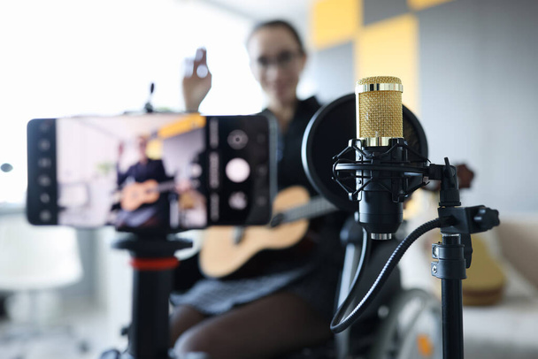 Donna in sedia a rotelle sta registrando lezione di chitarra online - Foto, immagini