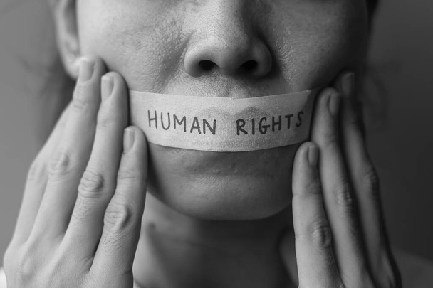 donna con bocca sigillata in nastro adesivo con messaggio sui diritti umani. Libertà di parola, libertà di stampa, dittatura di protesta, democrazia, libertà, uguaglianza e fraternità - Foto, immagini