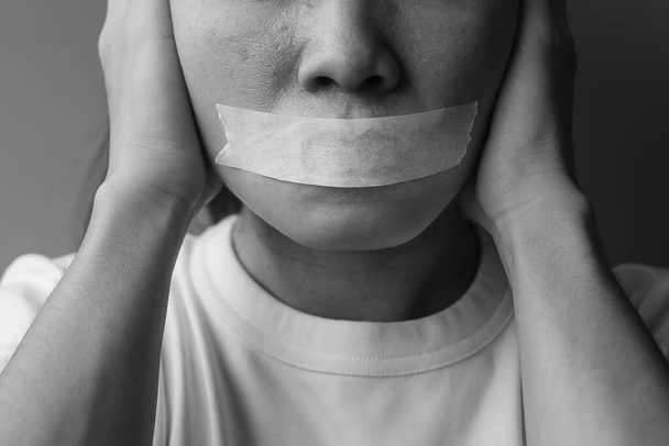 woman with mouth sealed in adhesive tape. Free of speech, freedom of press, Human rights, Protest dictatorship, democracy, liberty, equality and fraternity concepts - Photo, Image