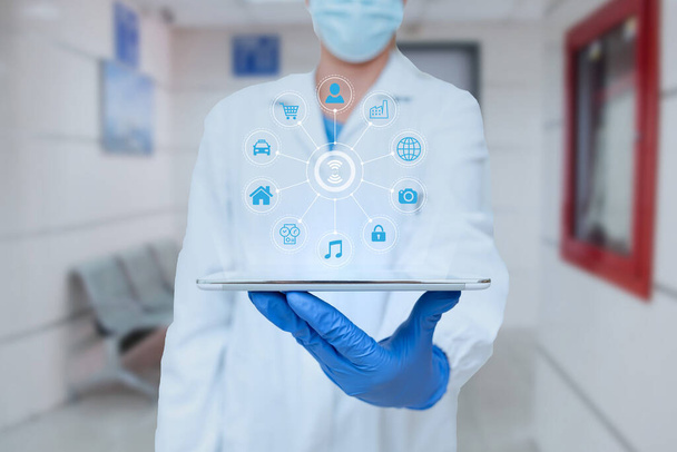 Dottore in uniforme in piedi Holding Tablet e virtualmente digitando con penna. Nurse Carrying Pad Digitando e visualizzando nuove tecnologie mediche futuristiche. - Foto, immagini