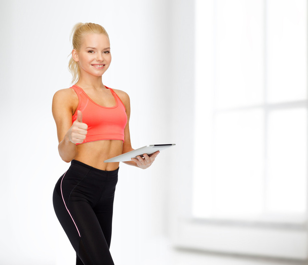 smiling sporty woman with tablet pc computer - Zdjęcie, obraz