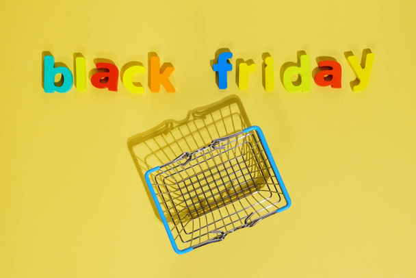 Inscription black Friday yellow background low prices, discounts, shopping on Black Friday. Flat lay - Zdjęcie, obraz