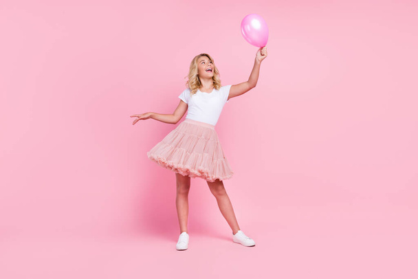 Full length photo of young cheerful girl happy positive smile look air balloon decoration isolated over pink color background - Fotografie, Obrázek