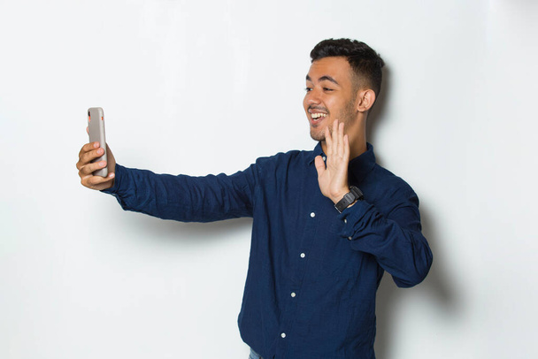 szczęśliwy młody biznesmen za pomocą telefonu komórkowego odizolowany na białym tle - Zdjęcie, obraz