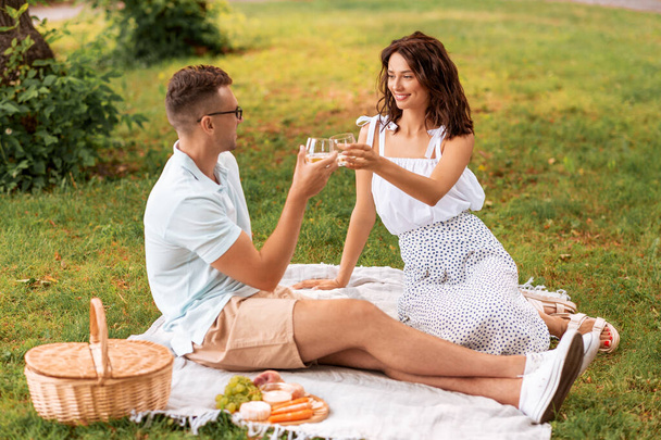 happy couple having picnic at summer park - Foto, afbeelding