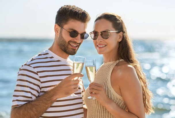 happy couple drinking champagne on summer beach - Zdjęcie, obraz