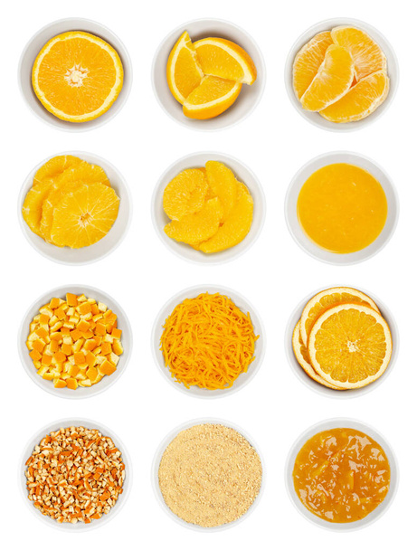 Sinaasappels in witte schalen. Verse sinaasappelhelft, partjes, segmenten, dwarsdoorsneden, superieure snede en geperst sap. Vers gesneden, gedroogd en gepoederd schil, schil, schil, jam en gedroogde plakjes. geïsoleerd, van bovenaf. - Foto, afbeelding