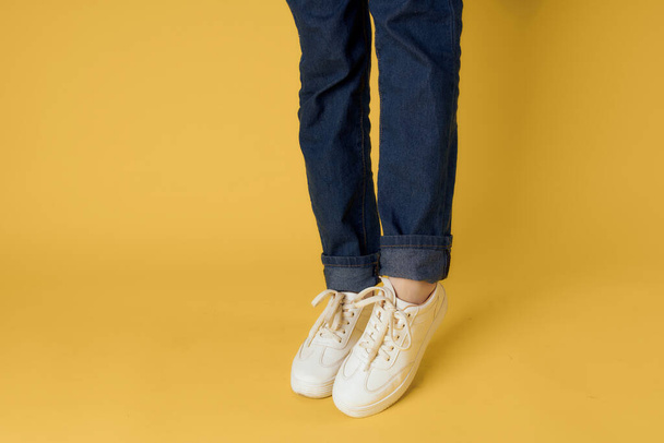witte sneakers mode moderne stijl gele achtergrond - Foto, afbeelding