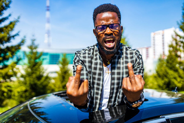 angry man shoving middle fingers from roof of his car - Foto, immagini