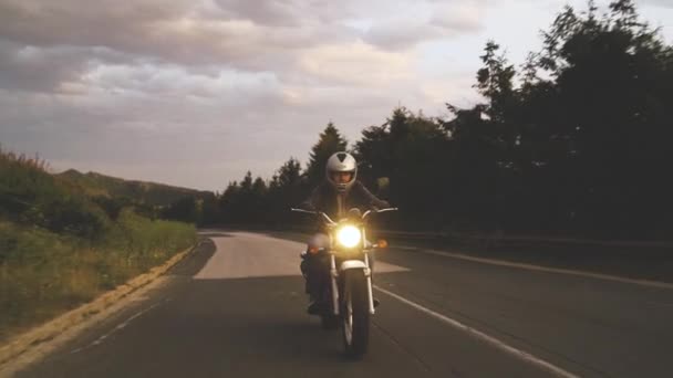Edessä näkymä moottoripyöräilijä vuoristotien avoin kypärä ratsastus vuosikerta moottoripyörä - Materiaali, video