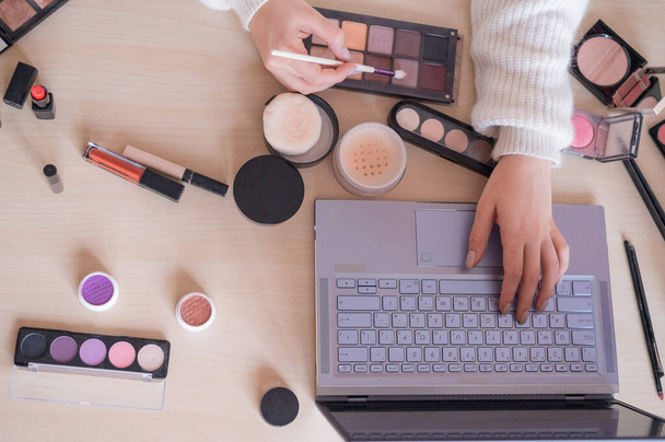 Online makeup tutorials. A woman watches a video training herself as a makeup artist on a laptop - Zdjęcie, obraz