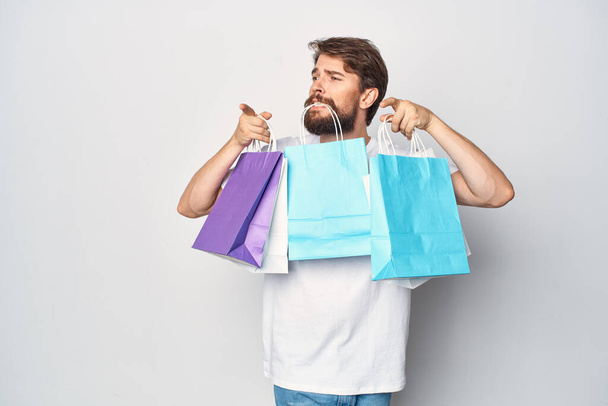 szakállas férfi sokszínű csomagokkal  - Fotó, kép
