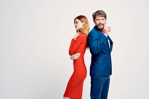 a man in a suit next to a woman in a red dress romance happy light background - Foto, Bild