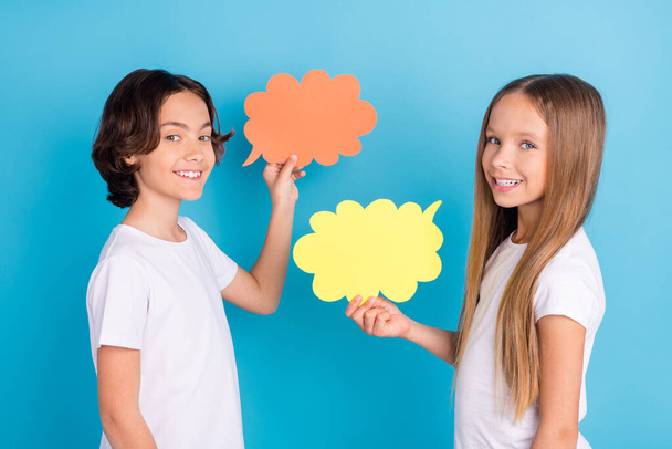 Photo of two sociable kids communicate present mind cloud wear white t-shirt isolated blue color background - Фото, изображение