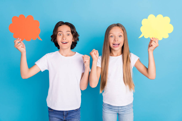 Photo of two champion kids hold mind clouds raise fist wear white t-shirt isolated blue color background - Φωτογραφία, εικόνα