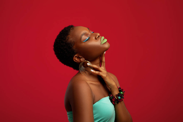 Hot zwart dame poseren op rood studio achtergrond - Foto, afbeelding