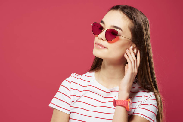 jolie femme portant des lunettes de soleil coiffure Glamor fond rose - Photo, image