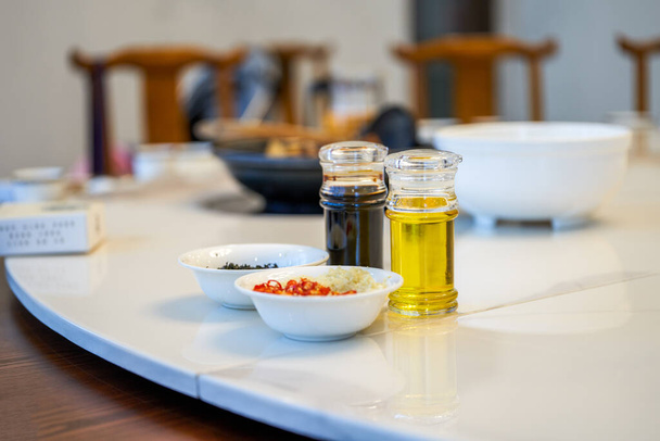 Combinación de condimentos en la mesa del hotel, salsa de soja, aceite comestible, chile perilla - Foto, imagen