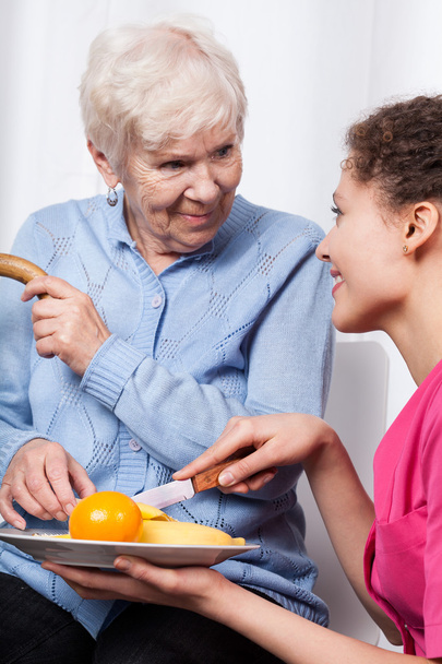 Nurse and elderly woman eating fruits - Fotó, kép