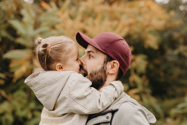 young, stylish bearded father walking with his little daughter in nature at sunset. Family photos of father and one child. - Photo, Image