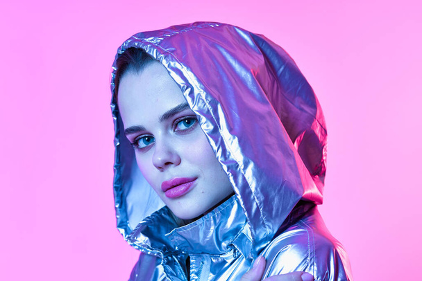 attractive woman in  silver hooded jacket posing  - Photo, Image