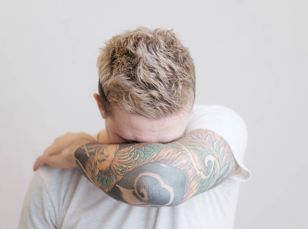 Portrait of a modern young guy with a tattoo on his arm. - Photo, image