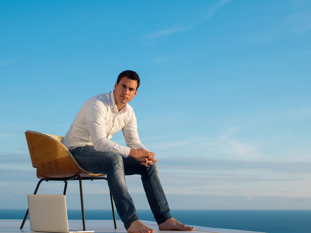 relaxed young man at home on balcony - Photo, Image