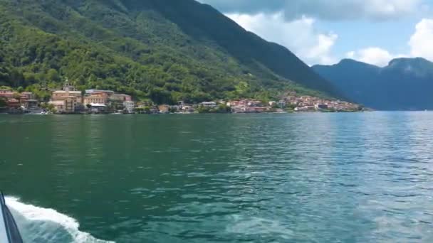 Navegar en el lago Como, en un ferry turístico, hacia la ciudad de Lezzenzo. Es un hermoso día soleado de verano, con unas pocas nubes. - Metraje, vídeo