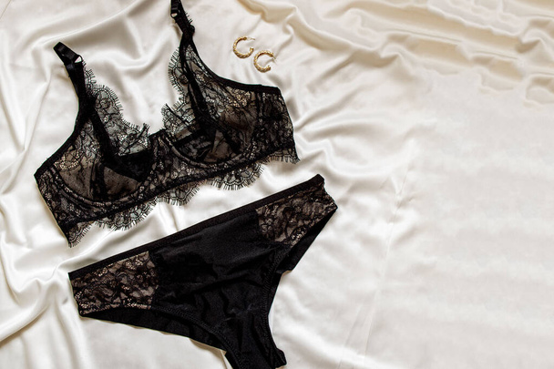Lace underwear on a beige silk, top view. Fashion concept. - Foto, Imagem