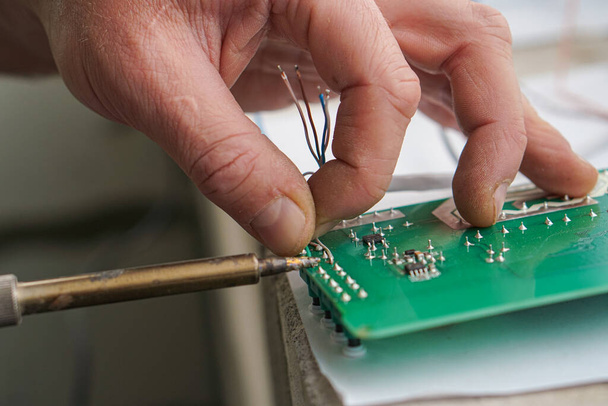 Electronic lab working place with soldering iron and circuit board - 写真・画像