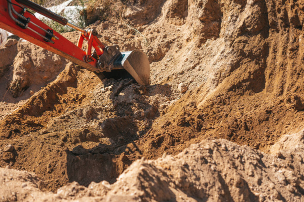 Excavator shovel digging on dirt on a construction site - Photo, Image