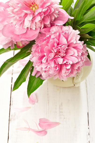 Peônias cor-de-rosa em vaso retro na mesa de madeira, tiro de close-up
 - Foto, Imagem
