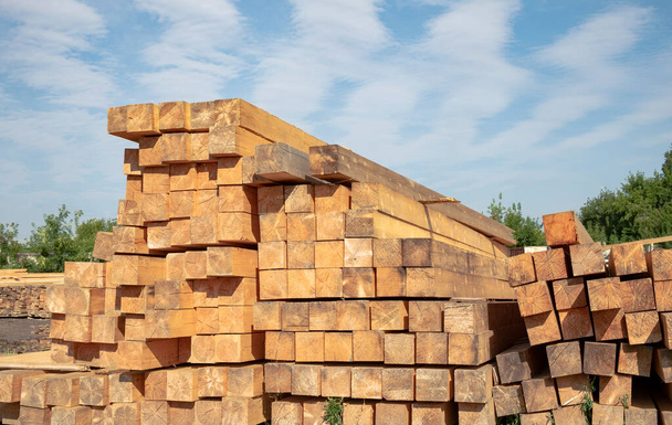 Stapel van zacht hout hout in een houthandel buiten tegen de blauwe lucht - Foto, afbeelding