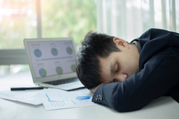 Üzleti partnerek koncepció egy férfi fiatal üzletember alszik az asztalon egy laptop és dokumentum, miután hosszú ideig dolgozott. - Fotó, kép