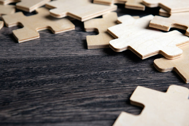 elementos de quebra-cabeça em um fundo de madeira como um enigma closeup - Foto, Imagem
