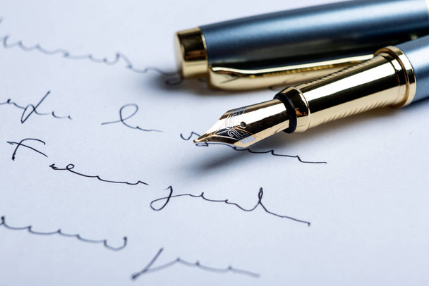 πένα στυλό σε χαρτί με μελάνι κείμενο στο χαρτί closeup - Φωτογραφία, εικόνα