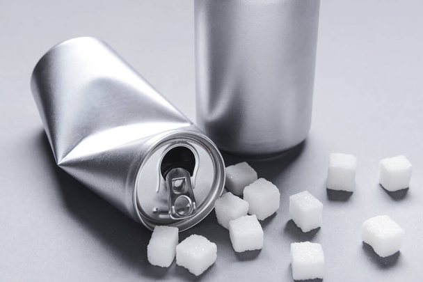Cans of soda and sugar on grey background. Diabetes concept - Photo, Image