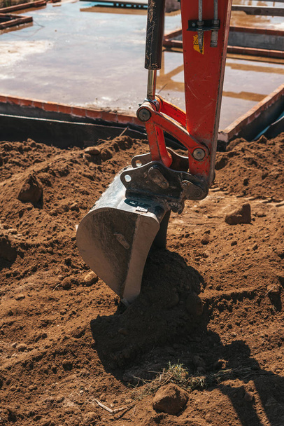 Экскаватор копает на грязи на строительной площадке - Фото, изображение