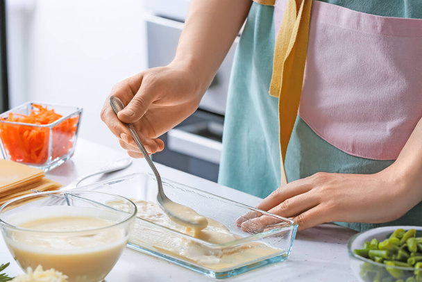 Žena připravuje chutné zeleninové lasagne u stolu v kuchyni, detailní záběr - Fotografie, Obrázek